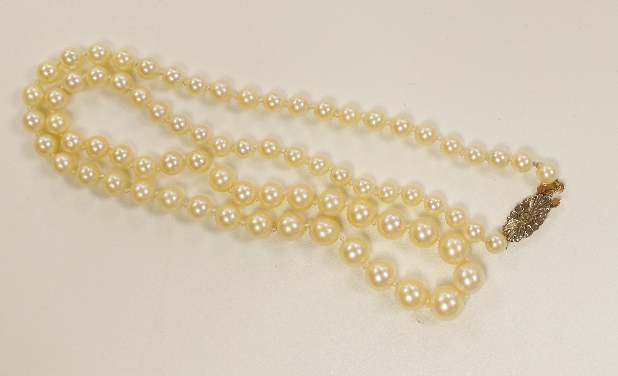 A single strand graduated cultured pearl necklace, with rose cut diamond set yellow metal clasp, 52cm.